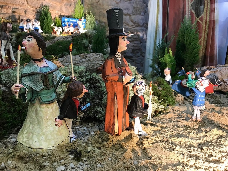 Els Gegants de la Caritat fumant una cigarreta i consultant el mòbil