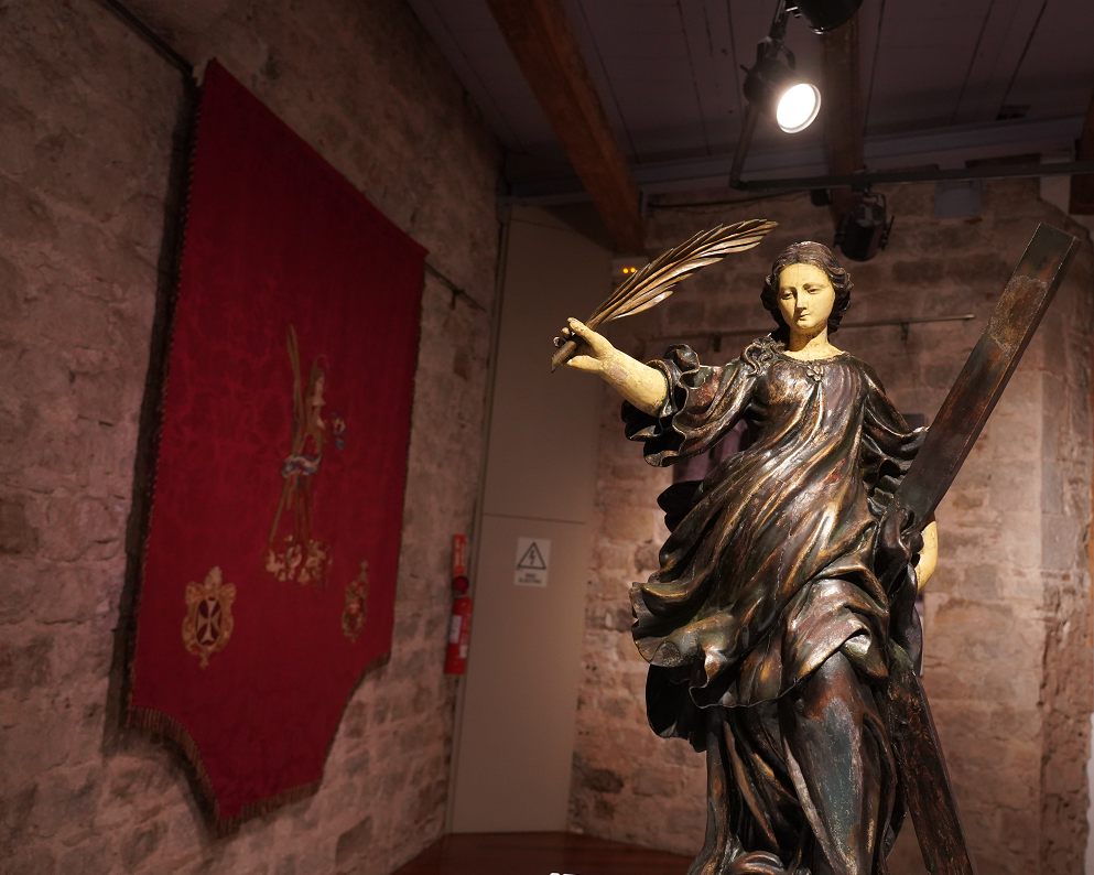 Escultura de santa Eulàlia de Pere Costa, i al fons, l'estandard de la confraria del segle XVIII